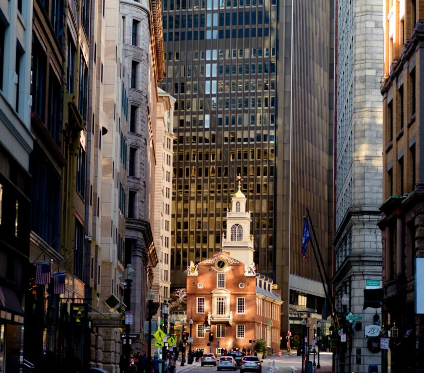 a city street with tall buildings and a clock tower