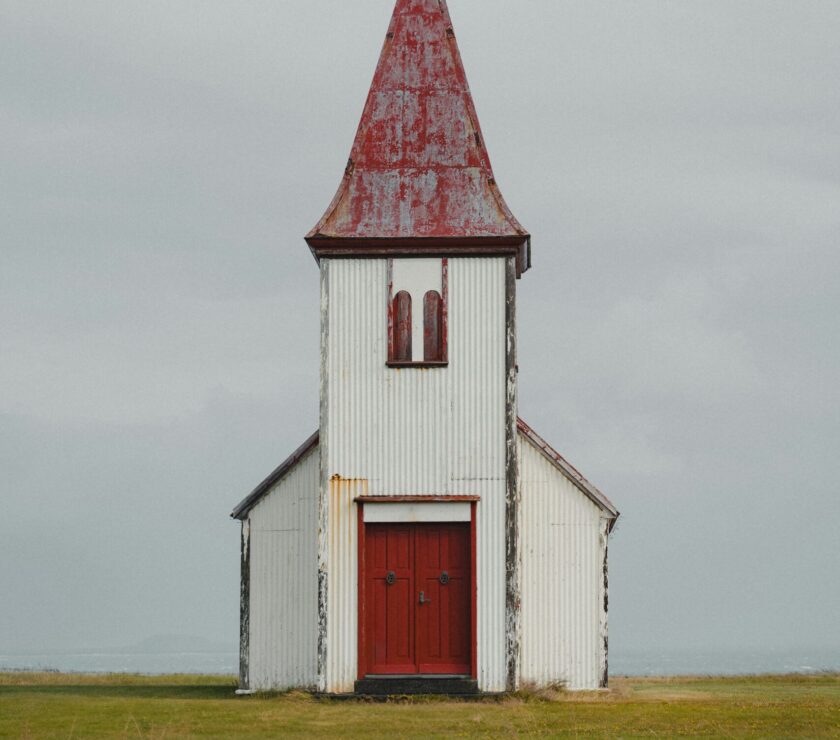 a white church with a red door and steeple